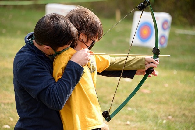 Maj. Ryan Hovatter, Command and General Staff Officer Course student, assists his 7-year-old son Patrick at the archery station during the Cub Scout Pack 1 Shooting Sports Day Oct. 17 at Hunt Lodge. Photo by Prudence Siebert/Fort Leavenworth Lamp
