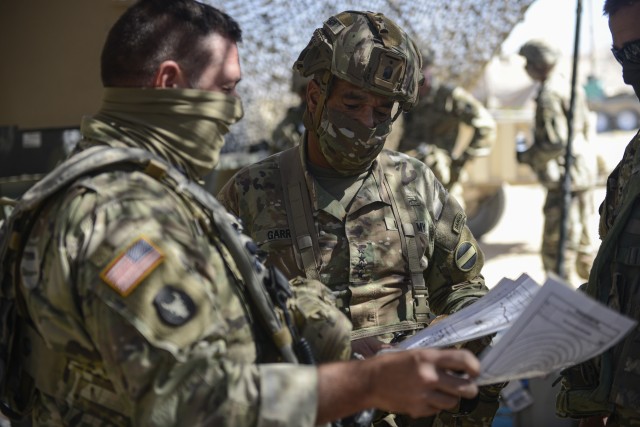 First Sgt. Chris Reed, left, assigned to Headquarters and Headquarters Company, 1st Armored Brigade Combat Team, 34th Infantry Division, discusses an optimized security plan of the brigade&#39;s main command post with Gen. Michael X. Garrett, the commanding general of U.S. Army Forces Command, in &#34;the box&#34; at the National Training Center in Fort Irwin, Calif., July 22, 2020. 