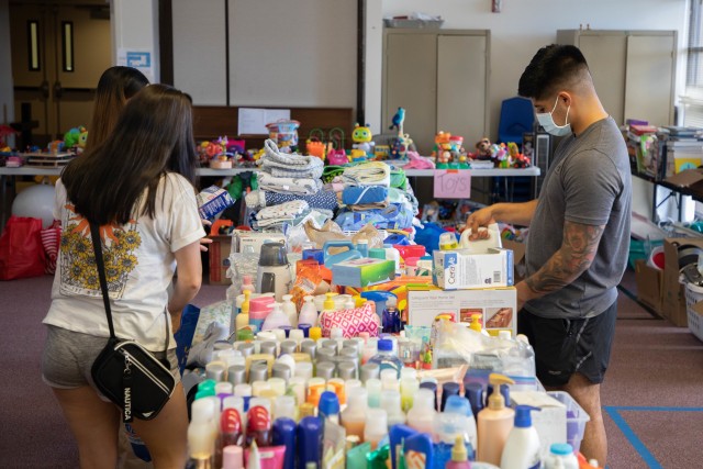 Sgt. Jesus Robles, assigned to 1st Battalion, 27th Infantry Regiment, 2nd Infantry Brigade Combat Team, 25th Infantry Division, and his wife Bianca sort through donated goods for thier family after their home burned down in a fire at Impact Chapel on Helemano Military Reservation, Hawaii on Sept. 28, 2020. (U.S. Army photo by Staff Sgt. Alan Brutus)