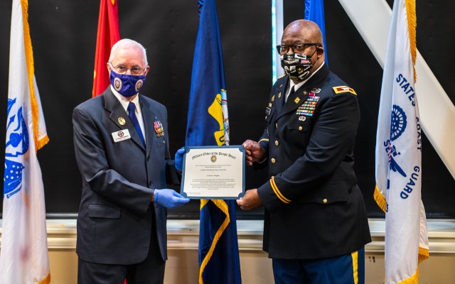 D. Leonard Robinson, left, junior vice commander of the Huntsville Purple Heart Chapter, presents a certificate of induction to Col. (ret) Fred Heaggans, held in Huntsville, Alabama, on 16 Oct. 2020. Heaggans received the Military Order of the Purple Heart and will be inducted into the Purple Heart Honor Roll at the Madison County Courthouse. (Photo by Richard Bumgardner, USASAC Public Affairs)