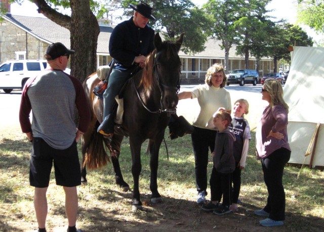 From left, Sgt. 1st Class Anthony Hantaq, Debbie Burroughs, Andrew Atkinson, 5, Abigail Atkinson, 8, and Jennifer Atkinson pepper Brent Harty, astride his horse Jeffers, with questions about his mid-19th century frontier life as a cavalryman. It...