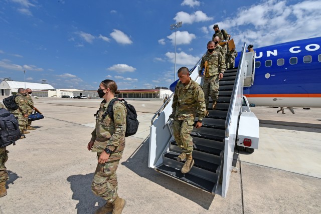 Soldiers depart from a chartered flight after arriving at Kelly Field, San Antonio from Fort Jackson.