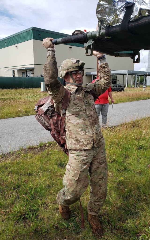 Sgt. 1st Class Scott P. Samson, combat medic, completes his Table VIII training as part of his military occupational specialty re-certification requirements. This specific training exercise involves Soldiers lifting and carrying a stretcher with a mannequin on it through a confined area and transporting the mannequin safely over an 8-foot wall. 