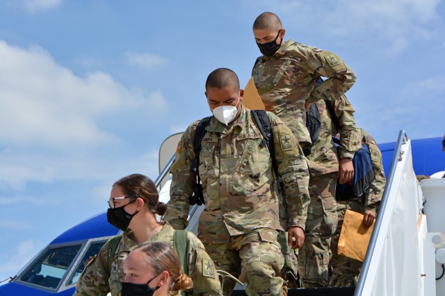 Soldiers depart from a chartered flight after arriving at Kelly Field, San Antonio from Fort Jackson.