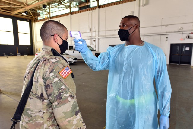 A Soldier has his temperature checked after arriving at Kelly Field from Fort Jackson on a chartered flight. Checking for symposiums are one of the many preventive measures in place to limit the spread of the coronavirus.