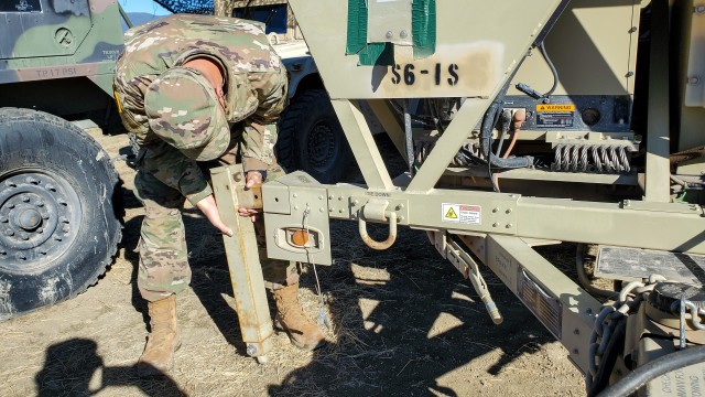 Spc. Christopher  Vorwaller, a multi-channel transmission operator assigned to the 217th Brigade Signal Company, Utah National Guard, attaches a leg to a satellite communication terminal at a mobile tactical operations center during a Warfighter...