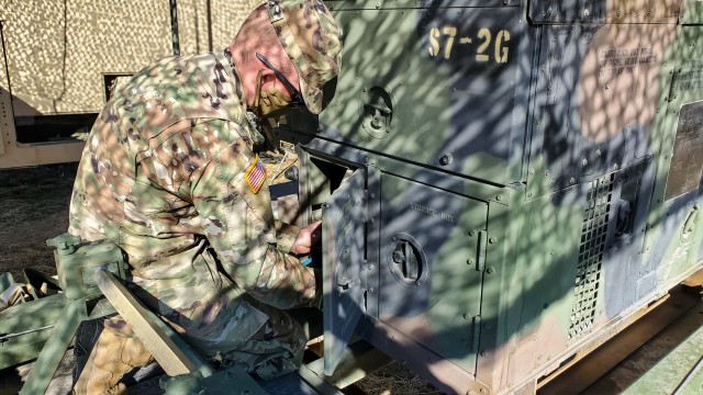 Spc. Talon Schick, a radio communications specialist assigned to the 217th Brigade Signal Company, Utah National Guard, inspects the connections from the field generator to the unit’s equipment at a mobile tactical operations center during a...
