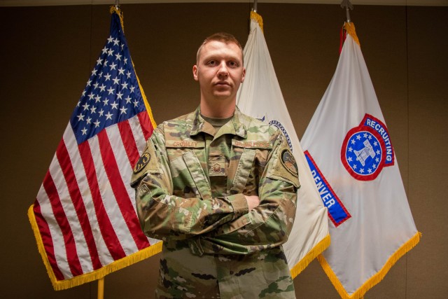 U.S. Air Force Master Sgt. John Crowley stands in front of the American flag and United States Army Recruiting Command flag Oct. 23, 2020 at the Denver Army Recruiting Battalion.