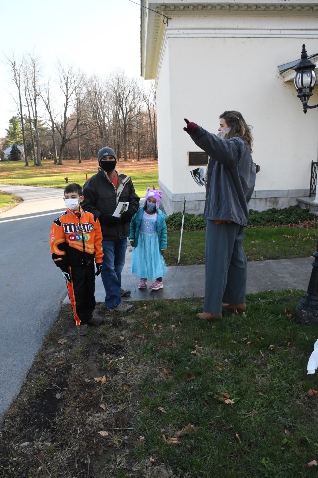 Carris Campbell, intern at LeRay Mansion, directs Fort Drum family members to a good starting point for a self-guided tour Oct. 30 during the Haunted LeRay Mansion event on post. (Photo by Mike Strasser, Fort Drum Garrison Public Affairs)