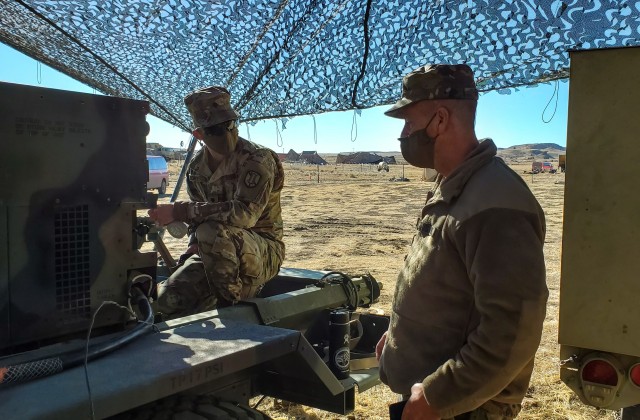 Spc. Talon Schick, a radio communications specialist assigned to the 217th Brigade Signal Company, Utah National Guard, explains his inspection of a field generator to Sgt. 1st Class Steve Burt, acting company first sergeant, at a mobile tactical...