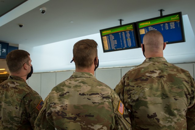 Army Spc. Kevin Hamilton, Sgt. Benjamin Zawacki and Staff Sgt. James Kociencki, Soldiers assigned to 105th Military Police Company, Buffalo, N.Y., check the arrival boards at Buffalo-Niagara International Airport, supporting the state’s travel...