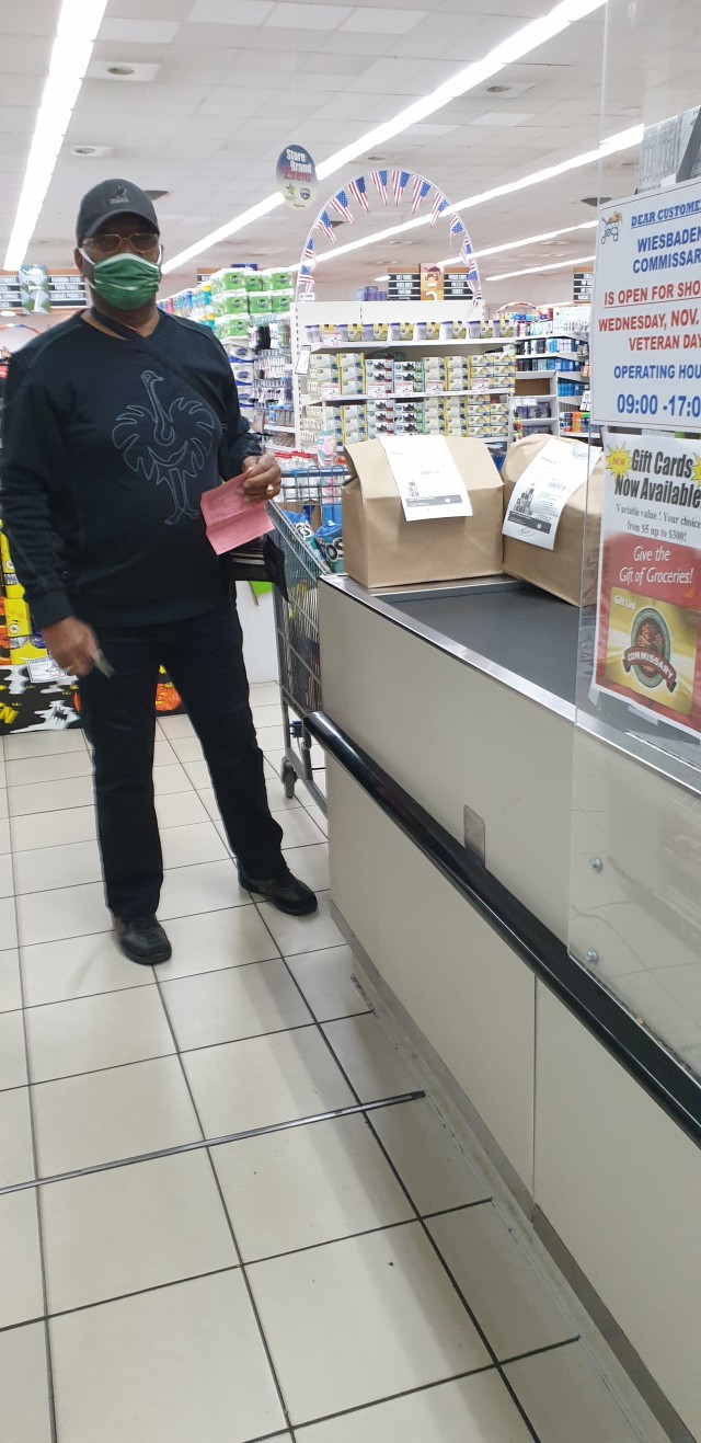 A shopper purchases two bags of food and other items Oct. 24 at the Commissary. The contents of the bags will be purchased by customers and used in the Army Community Service Holiday Assistance Baskets.