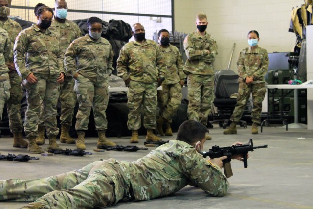 A group of 377th Theater Sustainment Command Soldiers watches a primary marksmanship demonstration during a battle assembly in Belle Chasse, Louisiana Oct. 25, 2020. The 377th TSC conducted its first hybrid battle assembly of the new fiscal year with some Soldiers attending in person while those living outside a 50-mile radius received training online. The command is using a combination of virtual and in-person training to increase safety in a COVID environment. 