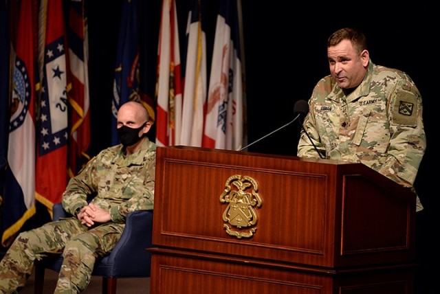 Outgoing Special Troops Battalion Commander Lt. Col. Charles D. Ausman delivers remarks as Combined Arms Center Chief of Staff Col. Thomas Bolen, left, and audience members present and watching via Facebook listen during Ausman's change of command...