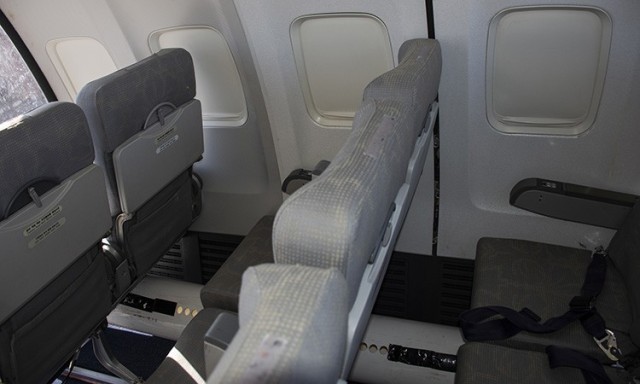 
The portion of the jet airliner fuselage to be used in the testing contains three rows of seats with armrests and folding seat-back trays, five windows, and overhead storage.
The white 8&#34; pipe on the floor replicates the airflow that typically envelops each passenger.