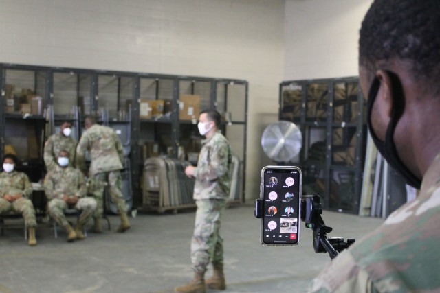 A U.S. Army Reserve Soldier monitors a cell phone during a live broadcast of primary marksmanship instruction for a battle assembly in Belle Chasse, Louisiana Oct. 25, 2020.  The 377th Theater Sustainment conducted its first hybrid battle assembly of the new fiscal year with some Soldiers attending in person and others living outside a 50-mile radius getting the training online. The command is using a combination of virtual and in-person training to increase safety in a COVID environment. 