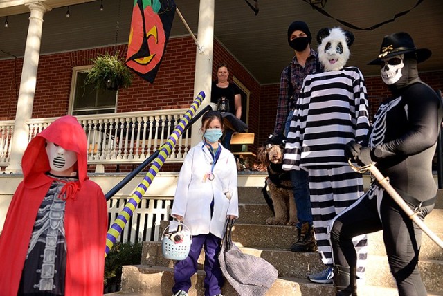 The Purvis family — 13-year-old Jeremiah as a hockey-mask clad and cape-draped ghoul, 8-year-old Julia as a veterinarian, mom Jennifer as herself staying home to deliver candy to trick-or-treaters via a decorated tube, golden doodle Cocoa as a...