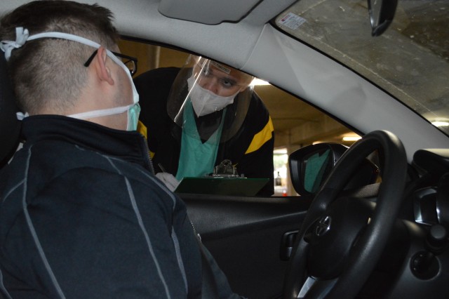 Spec. Diego Timoteo, an Army Combat Medic at Brooke Army Medical Center, Joint Base San Antonio - Fort Sam Houston, Texas, checks an incoming patient at BAMC’s drive-through COVID-19 testing area. Timoteo, a native of Brazil, recently earned his...