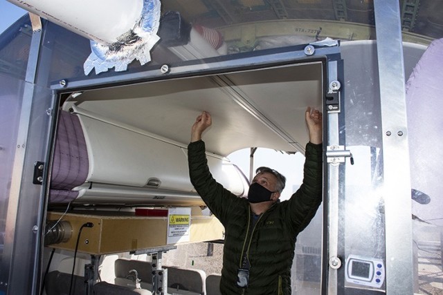 
Test Officer Angelo Madonna explains how outside air passes along the vent across the top of the fuselage&#39;s ceiling and is distributed to the passengers in seats. Each passenger may also adjust personal airflow with an overhead knob; this will also be studied. 
