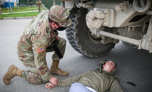 A Soldier assigned to the 566th Area Support Medical Company, 61st Medical Battalion, Fort Hood, Texas, applies a tourniquet to a mock patient during a mass casualty training event at the Joint Multinational Readiness Training Center in Hohenfels,...