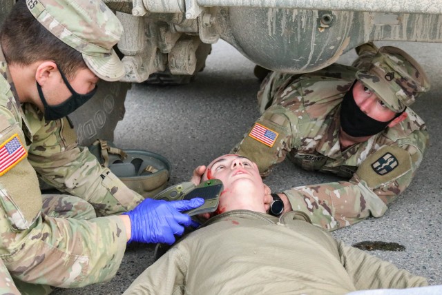 Soldiers assigned to the 566th Area Support Medical Company, 61st Medical Battalion, Fort Hood, Texas, apply a neck brace to a mock patient during a mass casualty training event at the Joint Multinational Readiness Training Center in Hohenfels,...