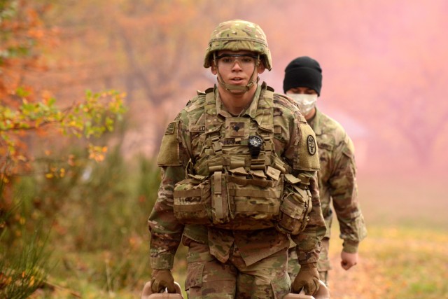 Spc. Brenden Lopez, assigned to U.S. Army Medical Department Activity-Bavaria, carries water jugs during the stress shoot portion of the Regional Health Command Europe Best Warrior competition Nov. 3 and 4 in Baumholder.  Lopez was the winner in...