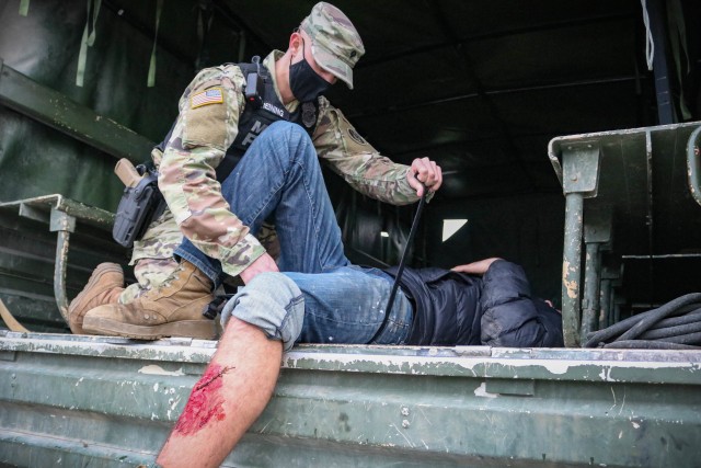A Maryland Army National Guard Soldier assigned to the 29th Military Police Company applies a tourniquet to a mock patient during a mass casualty training event at the Joint Multinational Readiness Training Center in Hohenfels, Germany, on Nov. 4,...