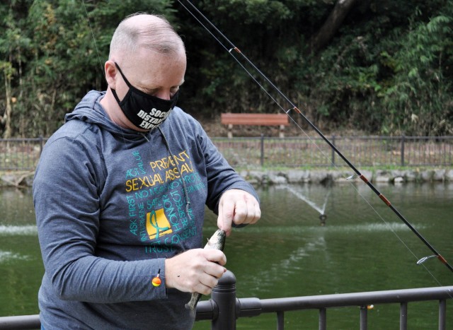 Tony Bean removes a hook from the mouth of a trout during the Community Trout Fishing Derby at Camp Zama, Japan, Nov. 7.