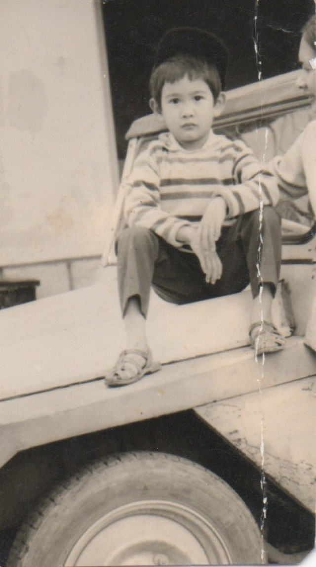 Lan Dalat rests on the family Citroen in Vietnam.