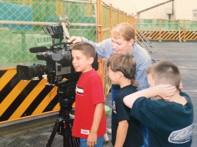 Navy Journalist Ellen (Maurer) Crown lets local military school children on Misawa Air Base, Japan, look through the lens of her broadcast camera during a video shoot, while she was assigned to the Armed Forces Radio and Television Service in...