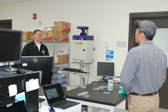 U.S. Army Engineer Research and Development Center, Construction Engineering Research Laboratory (CERL), chemist Dr. Kyoo Jo briefs the Principal Deputy Assistant Secretary of the Army for Installations, Energy and Environment Bryan Gossage on the lab’s research efforts related to synthetic biology at the CERL in Champaign, Ill., Oct. 30, 2020. (U.S. Army Corps of Engineers photo)