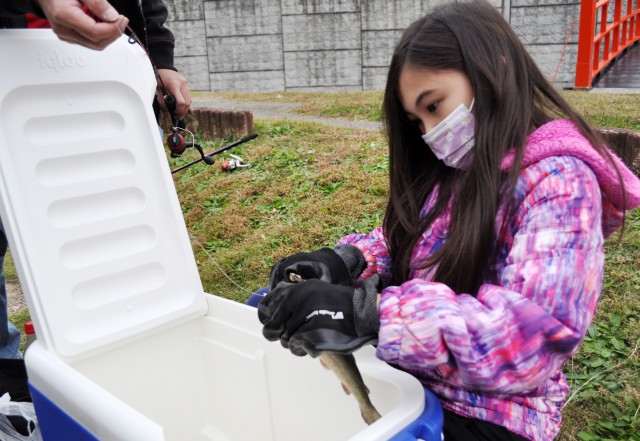 Arwen Tomoyasu, 9, removes a hook from the mouth of a trout during the Community Trout Fishing Derby at Camp Zama, Japan, Nov. 7.