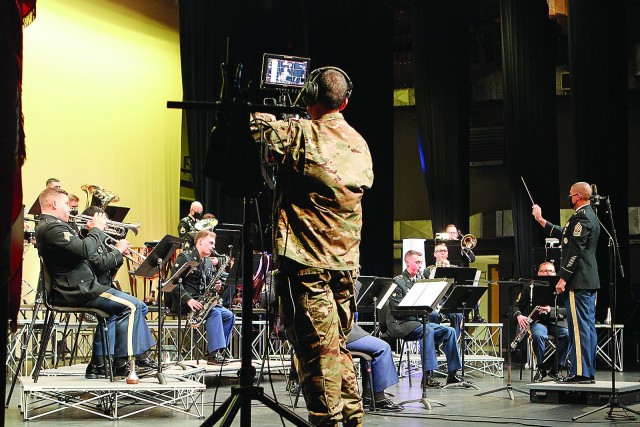 Standing stage right, Staff Sgt. Ryan Scott operates a camcorder on a jib shooting extreme close-ups or wide angle shots as requested via headset by Staff Sgt. Joshua Buxton. 77th Army Band musicians played their annual Veterans Day concert with...
