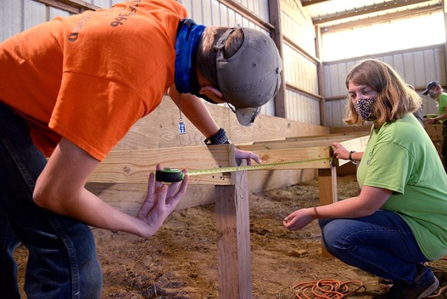 Brother-and-sister Scouts BSA members 13-year-old Aiden Harris, Troop 366, and 16-year-old Emily Harris, Troop 166, take measurements as they work on Emily's Eagle Scout project, a wheelchair-accessible loading ramp for use in an equine therapy...