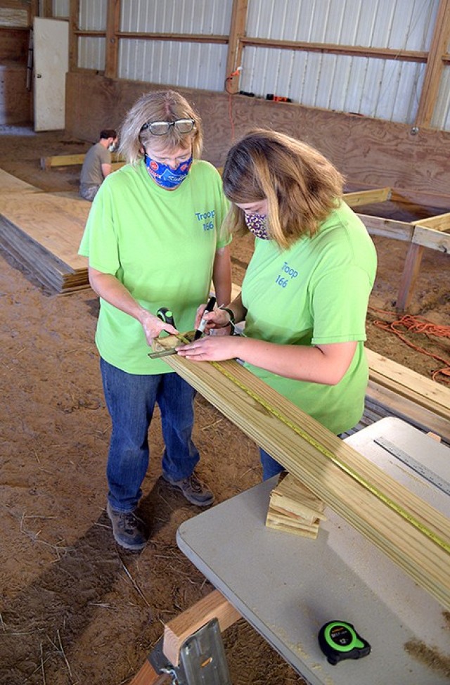 Darcy Harris and her 16-year-old daughter Emily Harris, member of Scouts BSA Troop 166, mark measurements on a board while working on Emily's Eagle Scout project, a wheelchair-accessible loading ramp for use in an equine therapy program Nov. 7 at...