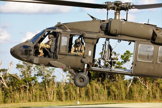 Staff Sgt. Michael Primavera, U.S. Army Aviation Battalion-Japan UH-60 mechanic, observes from a UH-60L Black Hawk Helicopter as it takes off to conduct Flight Deck Landing Practice in preparation for bilateral and joint deck landing operations in the Ryukyu southwest island archipelago chain Oct. 27. Orient Shield 21-1 is the largest U.S. Army field training exercise in Japan that tests and refines multi-domain operations. (U.S. Army photo by Maj. Elias M. Chelala)