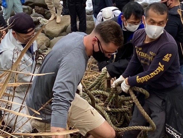 A Soldier from the 14th Missile Defense Battery at the Kyogamisaki Communication Site at Kyotango-Shi, Japan, hauls out trash as part of a community cleanup of Suisho-hama Beach, Nov 8. The battery, operated by the U.S. Army Space and Missile...