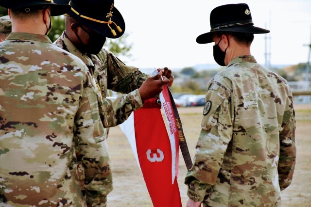3rd Calvary Regiment Command Sgt. Maj. Bradley Knapp and Commander, Col. Ralph Overland add the Armor and Calvary Leadership streamer to the Nomad Troop Guidon during the units Armor and Calvary Leadership Award ceremony on November 6 at Fort Hood, Texas.  (U.S. Army photo by Maj. Marion Jo Nederhoed, 3rd Calvary Regiment Public Affairs)