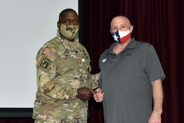 Lt. Gen. R. Scott Dingle, Surgeon General of the U.S. Army and Commanding General, U.S. Army Medical Command, presents Mr. Robert Preshong, Department of Combat Medic Training, with a Commander’s coin.