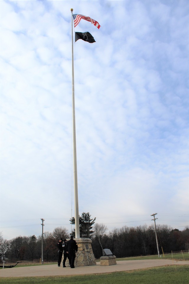 Officers with the Fort McCoy Directorate of Emergency Services Police Department raise the U.S. flag and the POW/MIA flag Nov. 12, 2020, at Fort McCoy, Wis. The team of officers replaced an older POW/MIA flag with a new one. The police regularly...