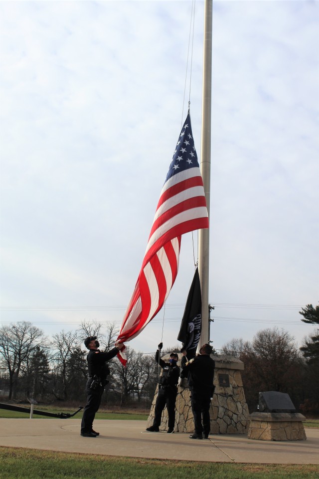 Officers with the Fort McCoy Directorate of Emergency Services Police Department raise the U.S. flag and the POW/MIA flag Nov. 12, 2020, at Fort McCoy, Wis. The team of officers replaced an older POW/MIA flag with a new one. The police regularly...