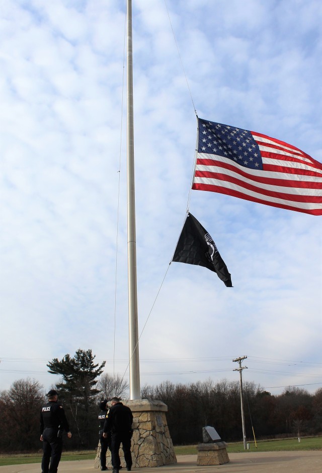 Officers with the Fort McCoy Directorate of Emergency Services Police Department raise the U.S. flag and the POW/MIA flag Nov. 12, 2020, at Fort McCoy, Wis. The team of officers replaced an older POW/MIA flag with a new one. The police regularly...
