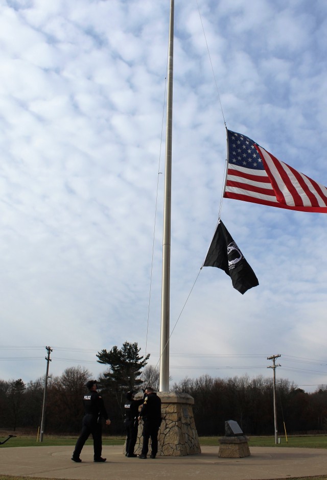 Officers with the Fort McCoy Directorate of Emergency Services Police Department raise the U.S. flag and the POW/MIA flag Nov. 12, 2020, at Fort McCoy, Wis. The team of officers replaced an older POW/MIA flag with a new one. The police regularly...