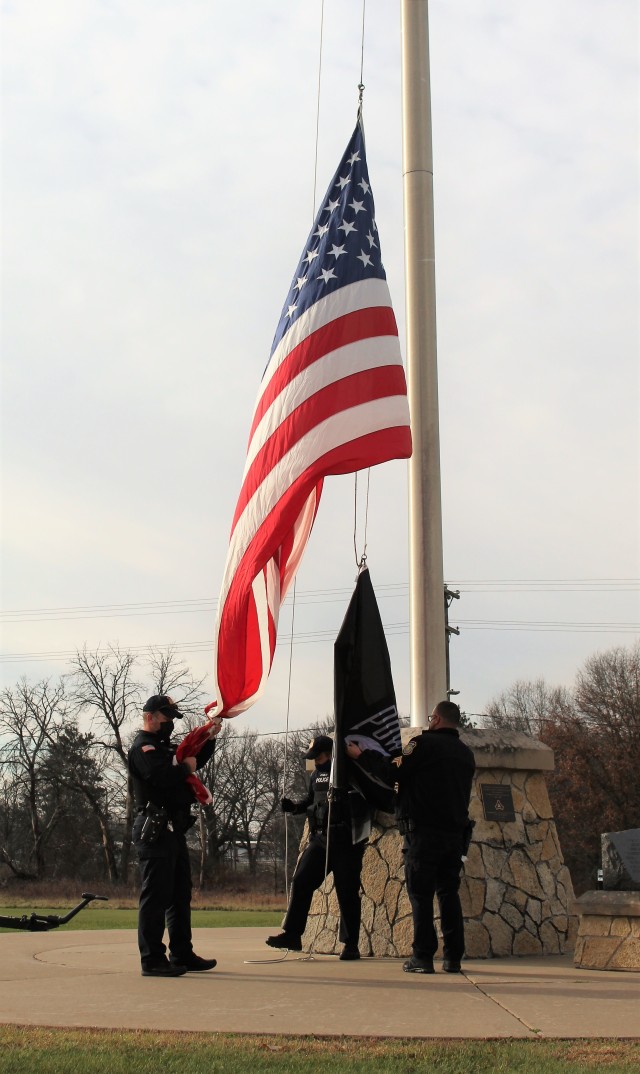 Officers with the Fort McCoy Directorate of Emergency Services Police Department raise the U.S. flag and the POW/MIA flag Nov. 12, 2020, at Fort McCoy, Wis. The team of officers replaced an older POW/MIA flag with a new one. The police regularly...