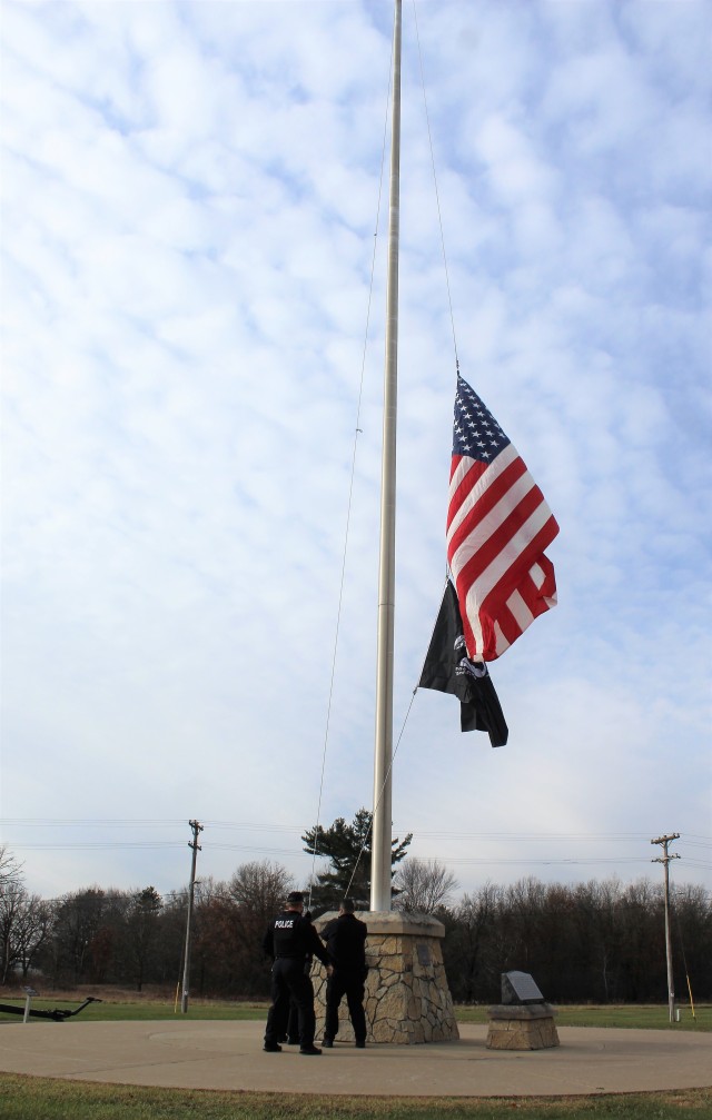 Officers with the Fort McCoy Directorate of Emergency Services Police Department raise the U.S. flag and the POW/MIA flag Nov. 12, 2020, at Fort McCoy, Wis. The team of officers replaced an older POW/MIA flag with a new one. The police regularly...