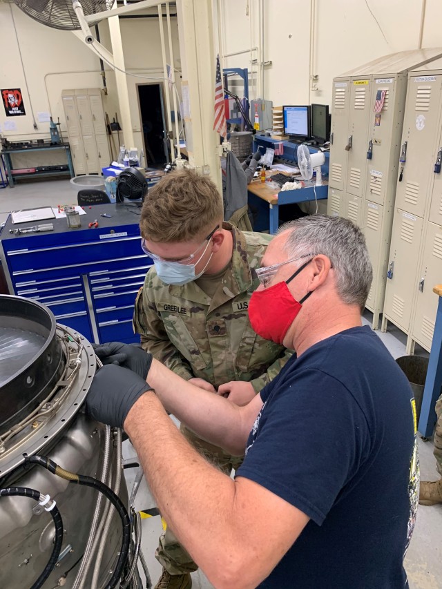Private First Class Rhiannon Moon works on the T-55 engine, installing the four and five bearing supply line hoses, under the tutelage and watchful eye of aircraft mechanic Thomas Sutherland. He is part of the of the 1st Air Cavalry Brigade, Fort Hood, TX,  receiving Depot Level training at the Corpus Christi Army Depot (CCAD).
