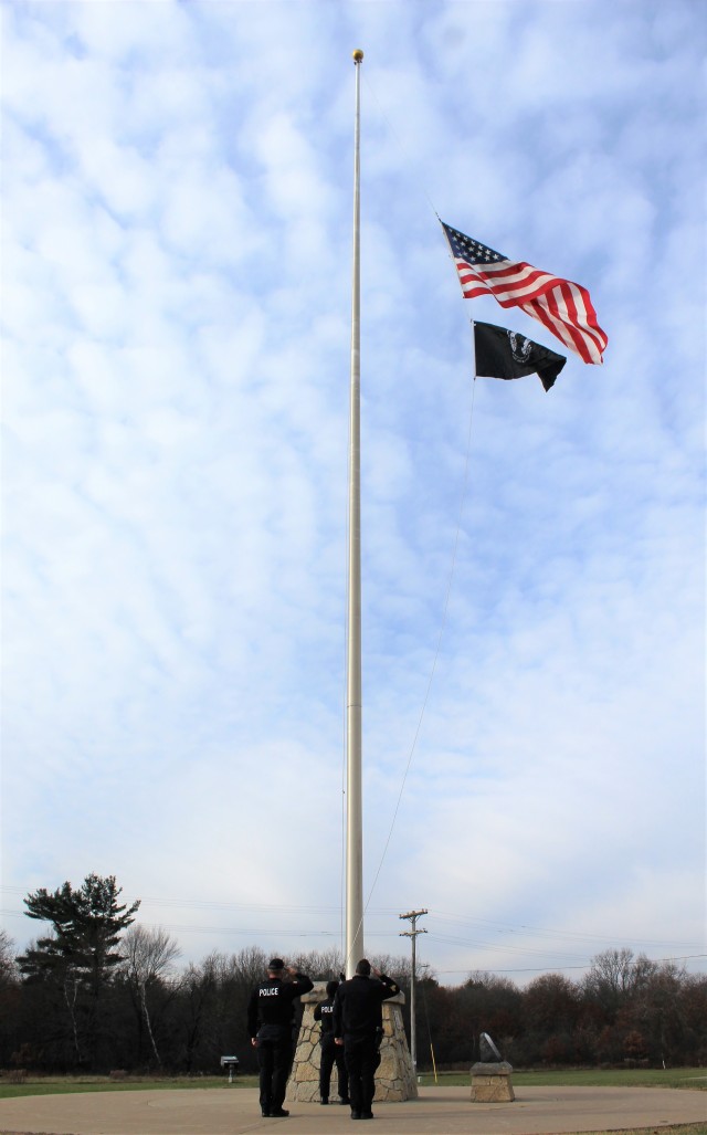 Officers with the Fort McCoy Directorate of Emergency Services Police Department raise the U.S. flag and the POW/MIA flag Nov. 12, 2020, at Fort McCoy, Wis. The team of officers replaced an older POW/MIA flag with a new one. The police regularly...