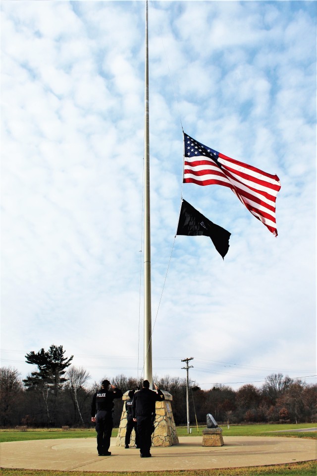 Officers with the Fort McCoy Directorate of Emergency Services Police Department raise the U.S. flag and the POW/MIA flag Nov. 12, 2020, at Fort McCoy, Wis. The team of officers replaced an older POW/MIA flag with a new one. The police regularly...