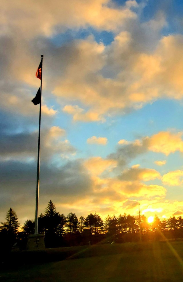 The U.S. flag is shown on the garrison flagpole on Veterans Day on Nov. 11, 2020, as the sun rises at Fort McCoy, Wis. In 1918, on the 11th hour of the 11th day of the 11th month, an armistice was declared between the Allied nations and Germany in World War I, history shows. More than 116,000 Americans died in World War I defending the lives and freedom of the United States’ European allies. The following year, President Woodrow Wilson proclaimed Nov. 11 as the first commemoration to honor the Soldiers who fought in that war, and the day was originally known as Armistice Day. Nov. 11 became a federal holiday in 1938, and in 1954 Congress decided to change the day to Veteran's Day. This was because they wanted to honor the veterans of all wars including World War II and the Korean War. (U.S. Army Photo by Scott T. Sturkol, Public Affairs Office, Fort McCoy, Wis.)