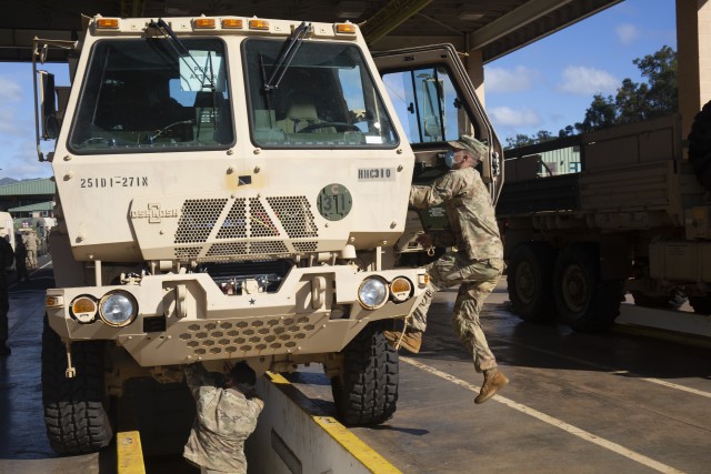 Soldiers perform a final maintenance inspection of a vehicle before it can be fully processed.